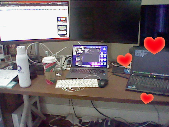 Dual monitors connected to an M1 Macbook Air, and an x200 with hearts surrounding it